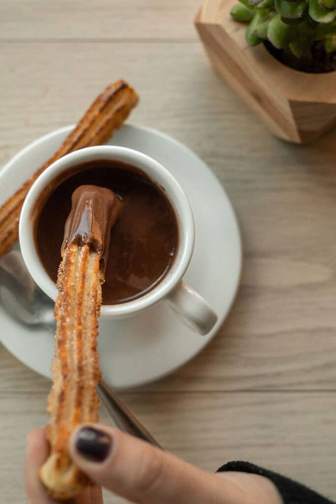 Churros crujientes servidos con chocolate caliente en una chocolatería madrileña